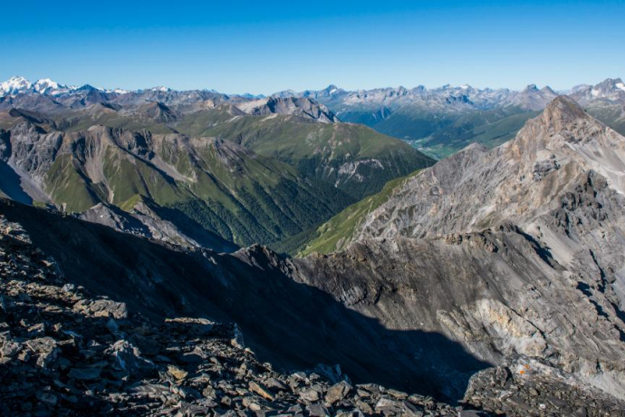 View from Piz Quattervals to the south. To the right, Piz d’Esan, in the middle the Val Trupchun, and in the background the villages of Madulain and La Punt in the Upper Engadin.