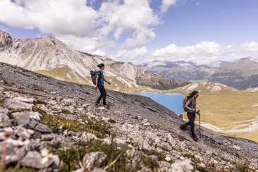 Wandern im Val Müstair mit Aussicht auf Berge und Bergsee.